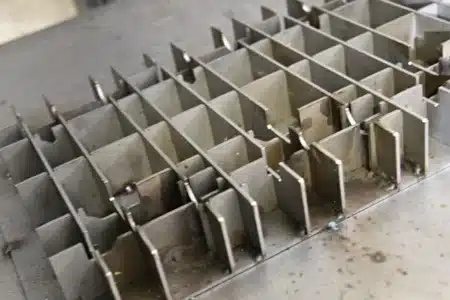 Custom metal grid-style welding fixture designed for organizing or supporting multiple parts during welding or fabrication processes.